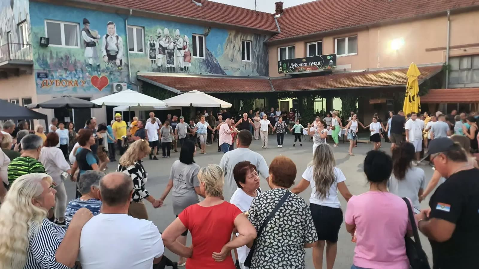 Kolo ispred kafane sa muralom „Дубока у срцу“ u Duboki